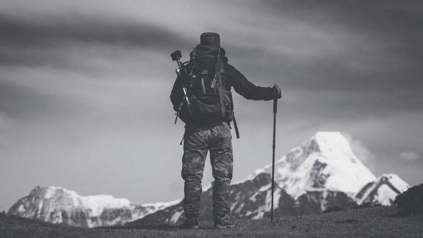 Alpiniste de dos observant la montagne, photo en noir et blanc