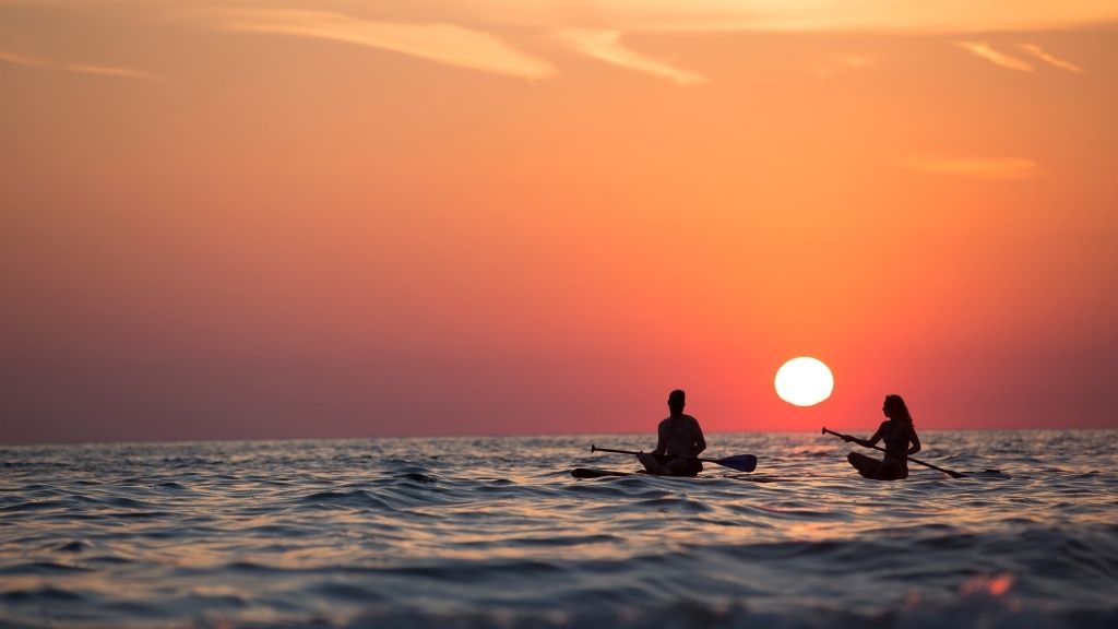 Couple en stand up paddle sur l'eau au coucher du soleil, bassin d'arcachon