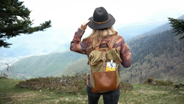 Femme avec un chapeau outdoor de dos avec son sac à dos à observer la montagne